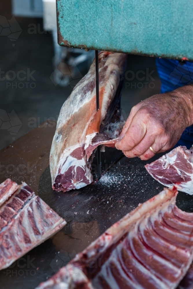 mobile butcher using electric saw to cut through bones - Australian Stock Image