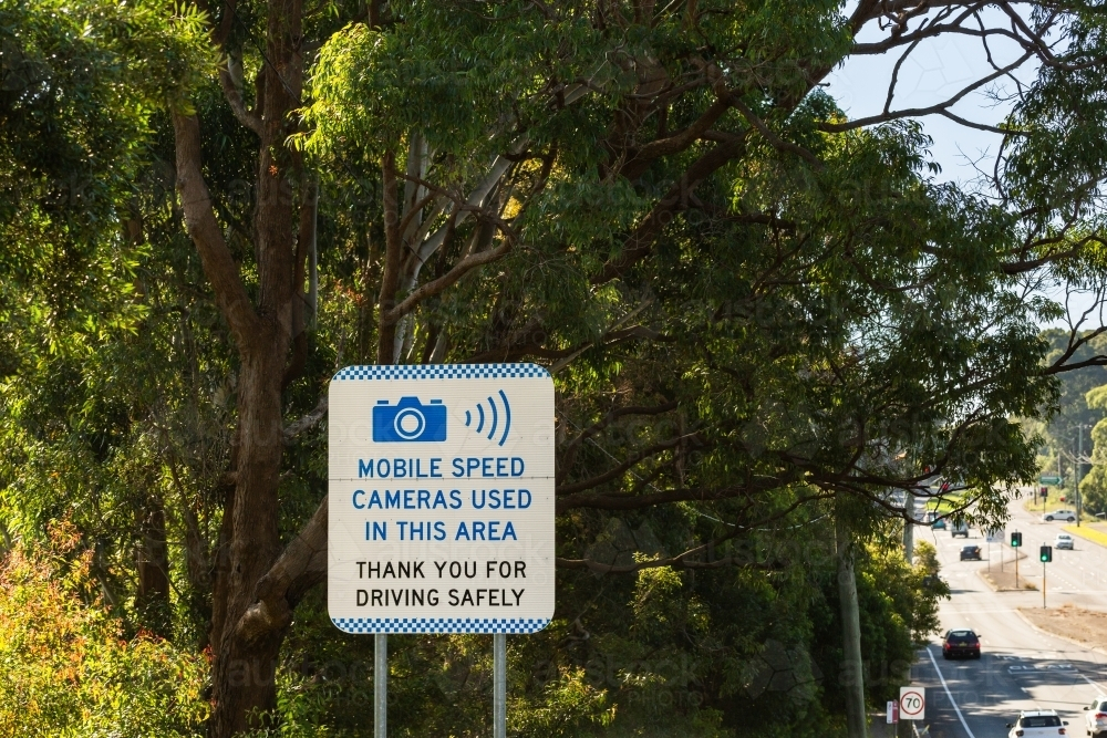 Mobile speed cameras used in this area thankyou for driving safely sign beside city suburb road - Australian Stock Image