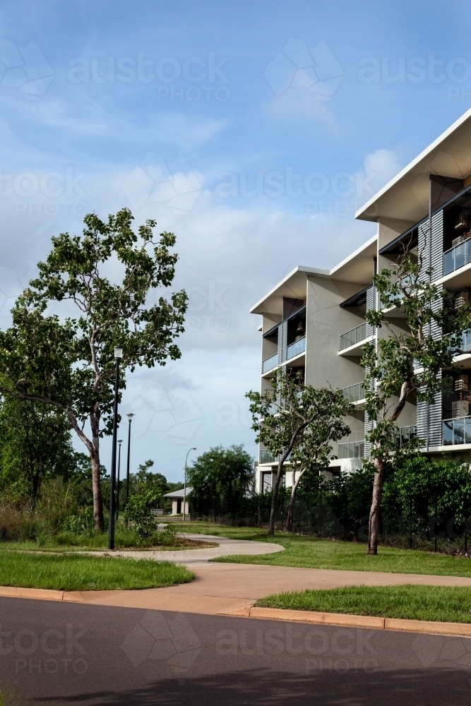 Modern apartment building with green space and blue skies - Australian Stock Image