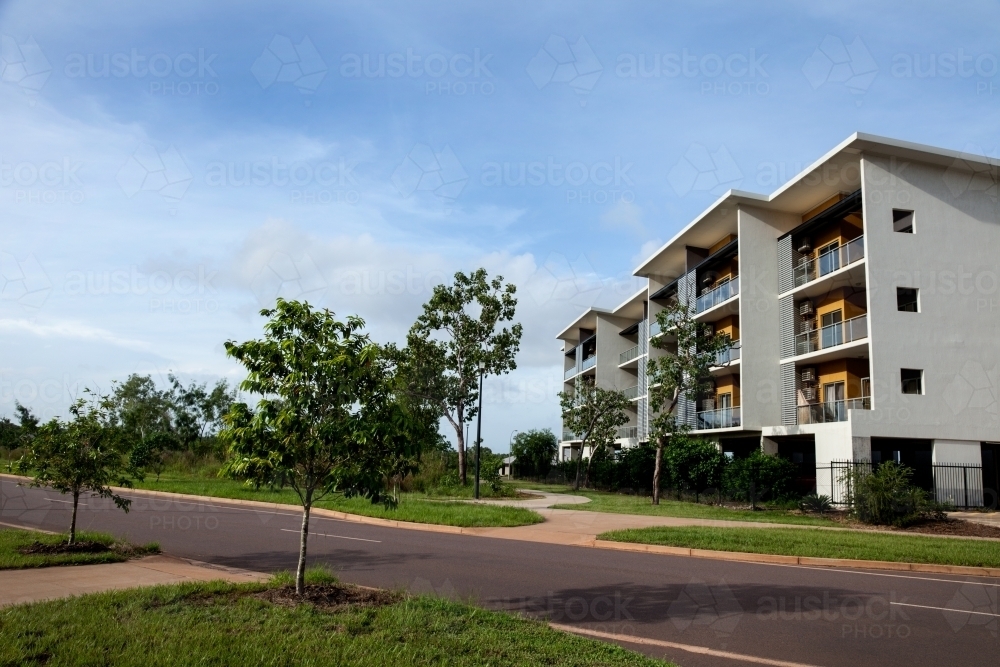 Modern apartment building with green space and blue skies - Australian Stock Image