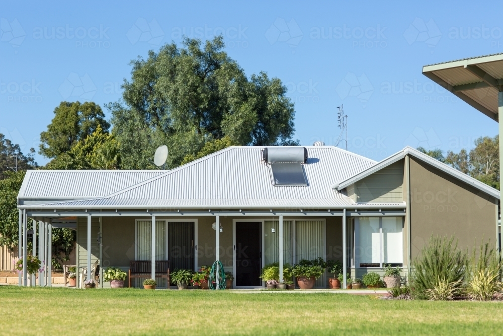 Modern house with solar hot water system on roof - Australian Stock Image