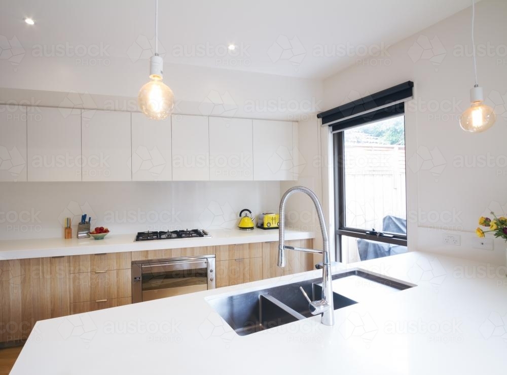 Modern kitchen with pendant lighting and sunken sink in bench - Australian Stock Image