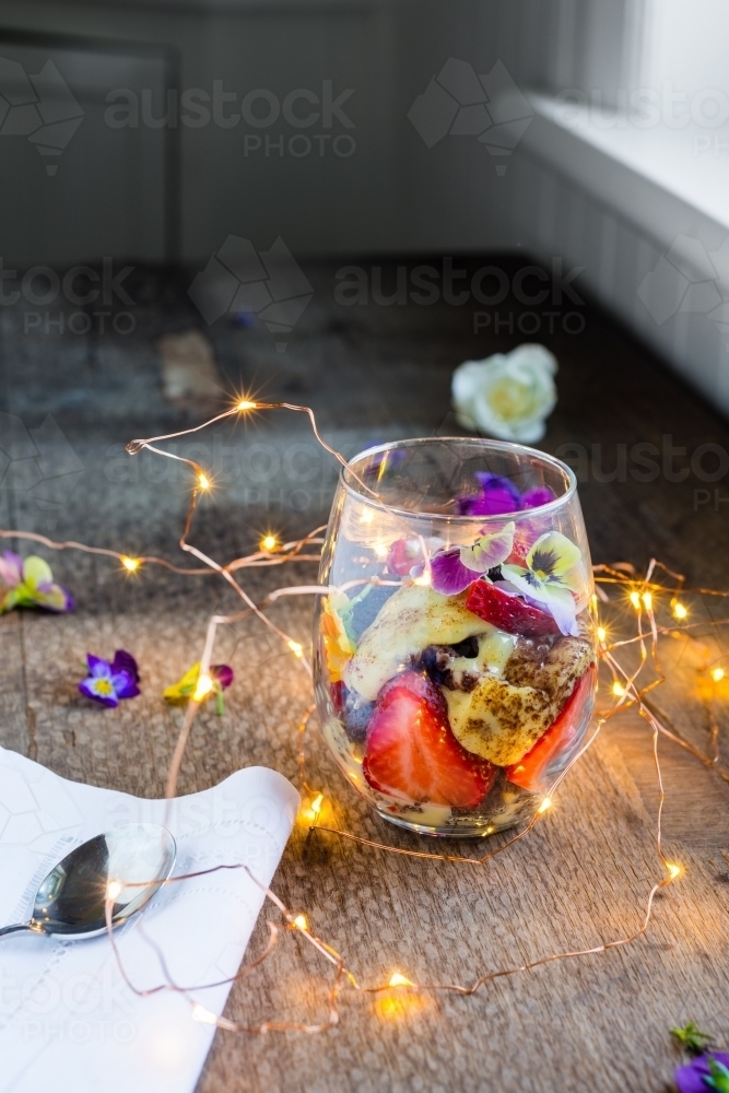 modern trifle dessert, in a stemless glass with fairy lights - Australian Stock Image