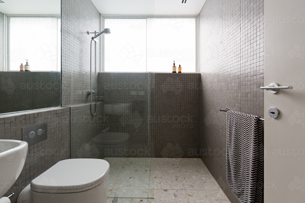 Modern walk in shower with mosaic full height tiles and terrazzo floor - Australian Stock Image