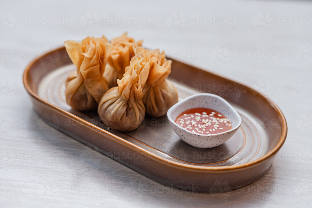 Money bags arranged on a plate with side sauce - Australian Stock Image