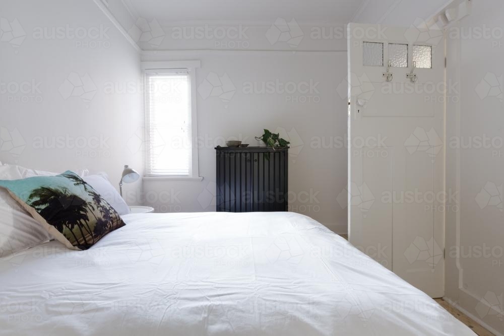 Monochrome bedroom with decorator cushion in white vintage interior - Australian Stock Image