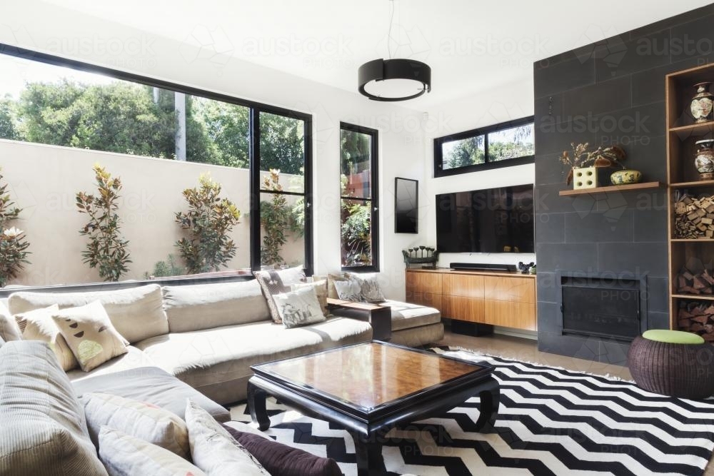 Monochrome living room with wood and grey tiling accents and chevron pattern rug - Australian Stock Image