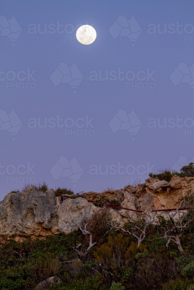 Moon rising above coastal cliff - Australian Stock Image