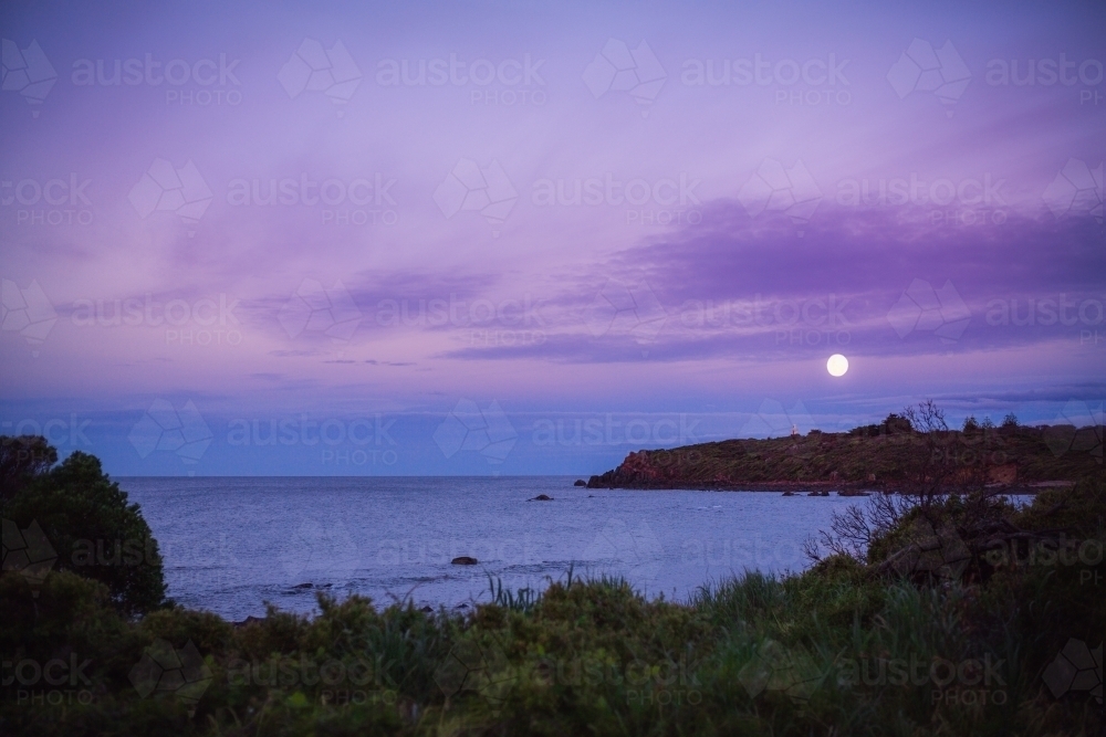 Moon rising over coastal landscape - Australian Stock Image