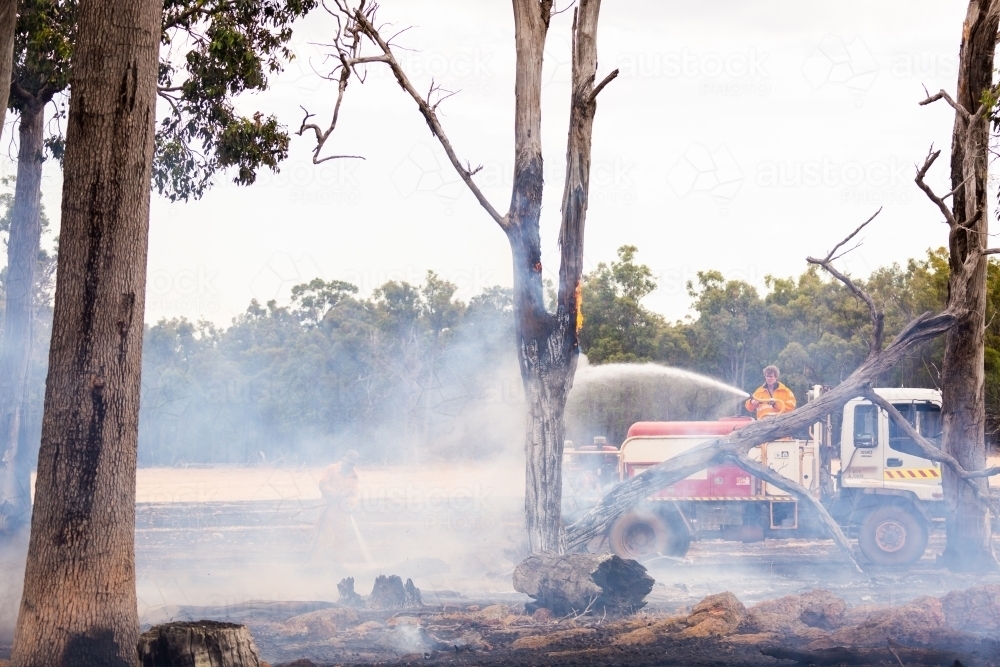 mopping up after a fire on a farm - Australian Stock Image