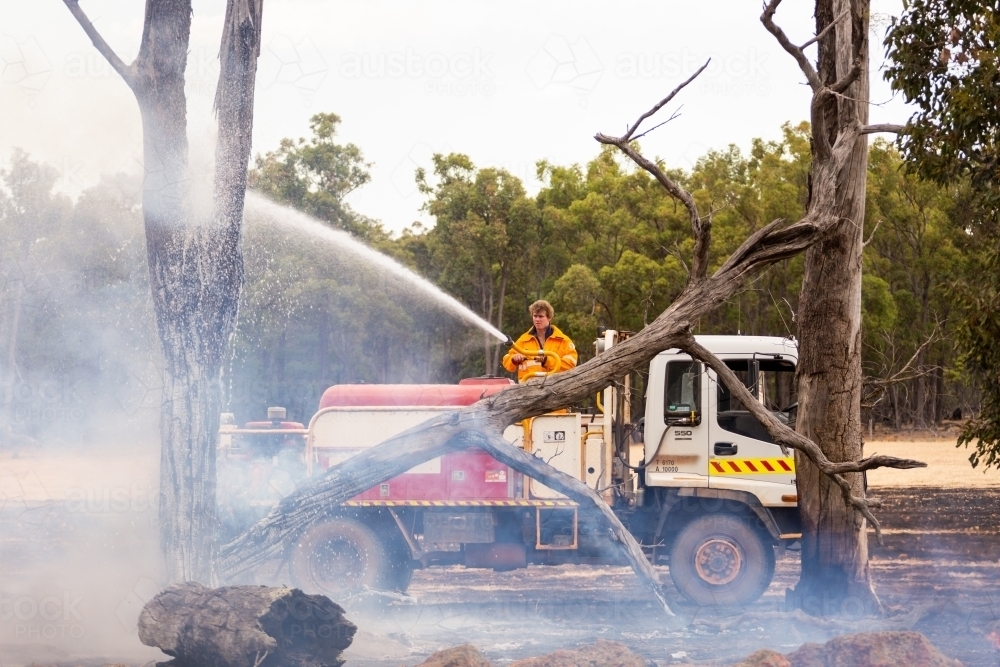 mopping up after a fire on a farm - Australian Stock Image