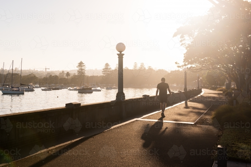 Morning exercise by the water along the promenade - Australian Stock Image