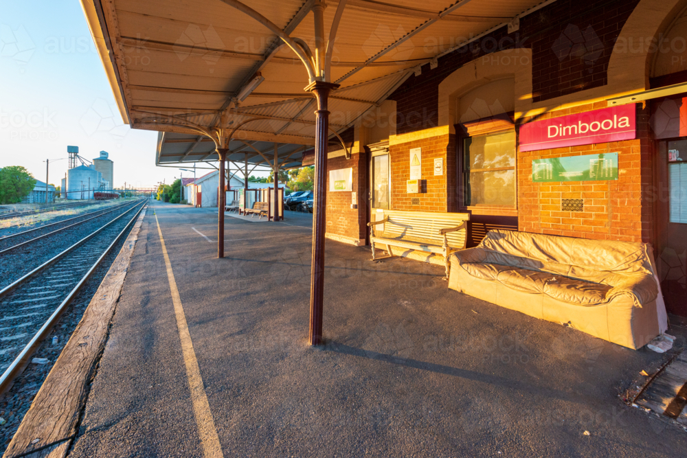 Morning light on Dimboola railway station platform with old benches and tracks - Australian Stock Image
