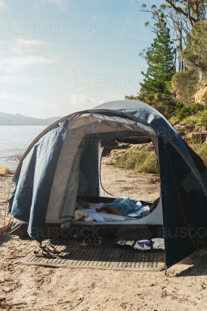 morning light on tent in a remote location by the sea - Australian Stock Image