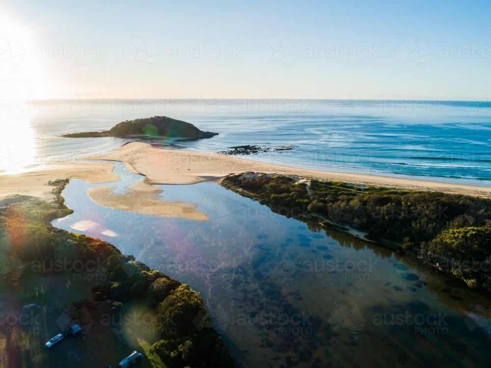 Morning light over lake where it opens to the sea with island - Australian Stock Image