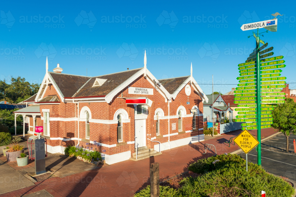 Morning sun on the historic Dimboola Post Office with its red brick facade and signpost - Australian Stock Image
