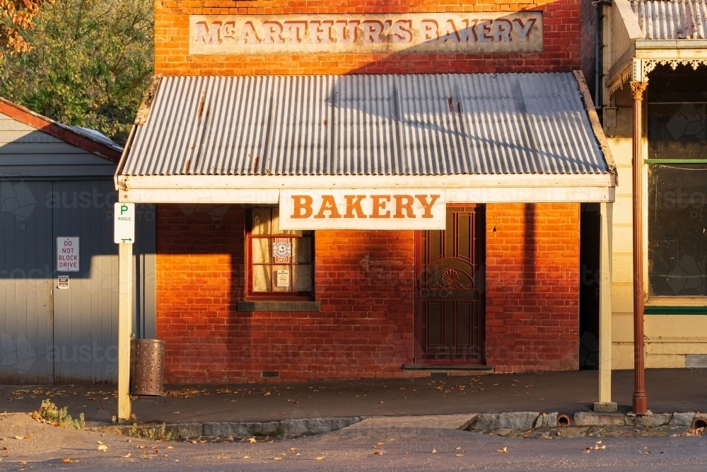 Morning sunshine on the front of a small brick bakery shop front - Australian Stock Image