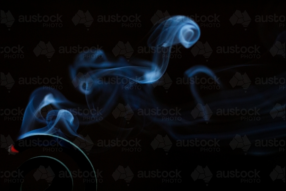 Mosquito coil smouldering in darkness - Australian Stock Image