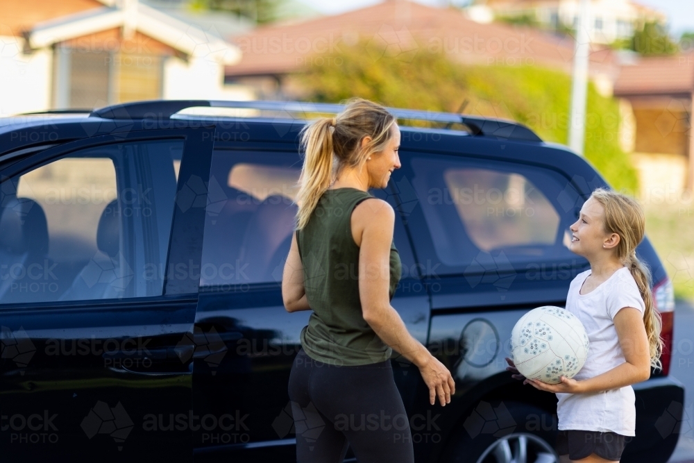mother and child near car going to netball training - Australian Stock Image