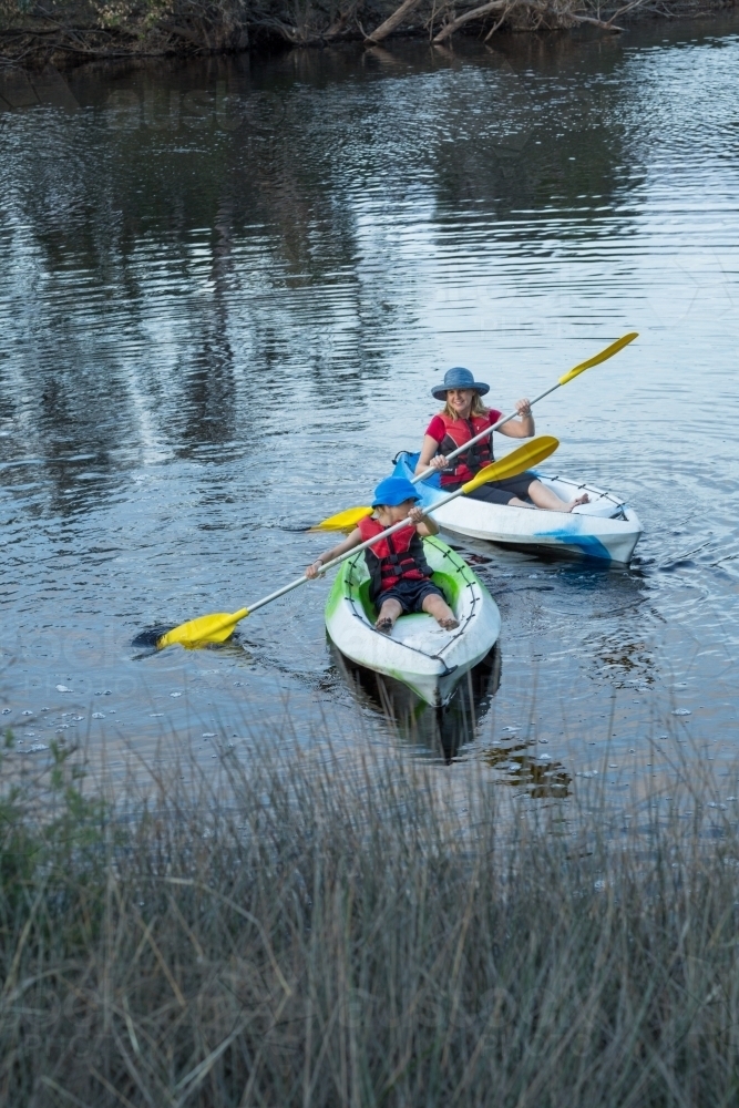 Mother and child on river in kayaks - Australian Stock Image