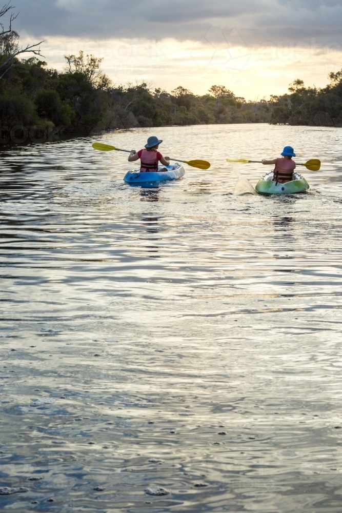 Mother and child paddling kayaks on a river - Australian Stock Image