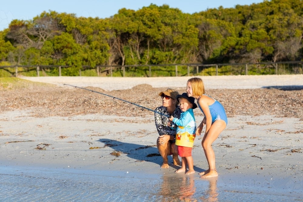 mother and children fishing on the beach - Australian Stock Image