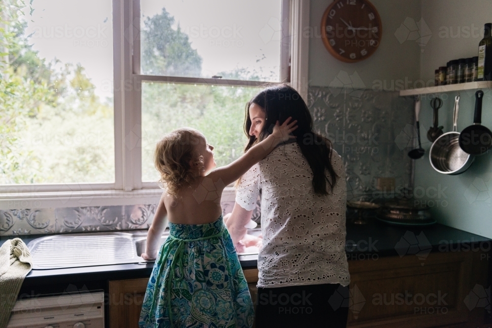 Mother and daughter at the kitchen sink - Australian Stock Image