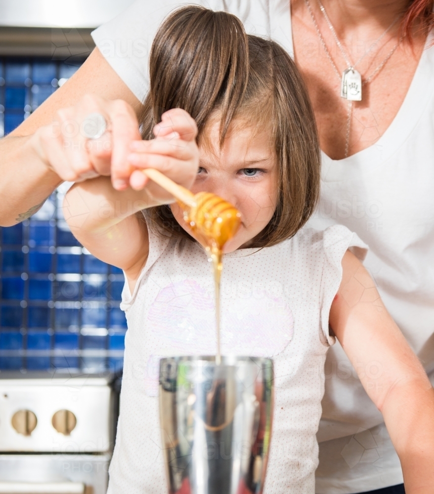 Mother and daughter cooking at home - Australian Stock Image