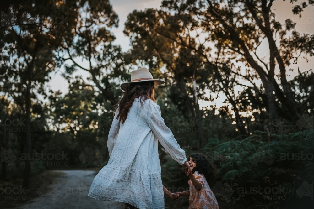 Mother and daughter holding hands at the park - Australian Stock Image