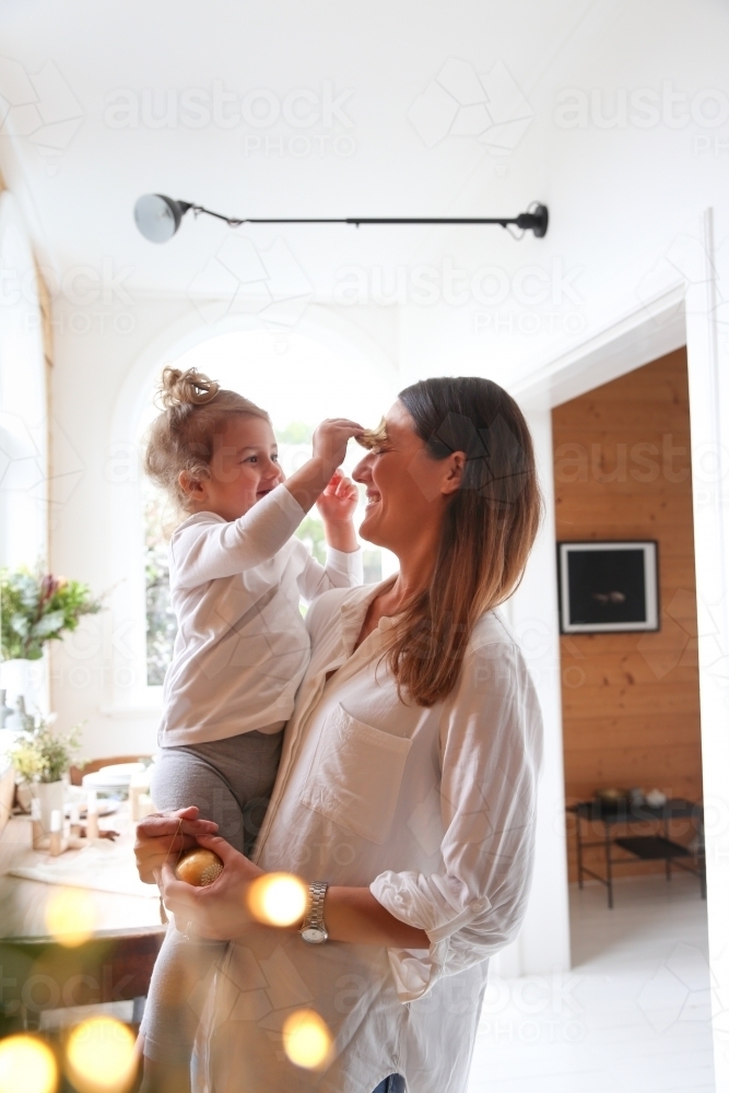 Mother and daughter looking at each other smiling - Australian Stock Image