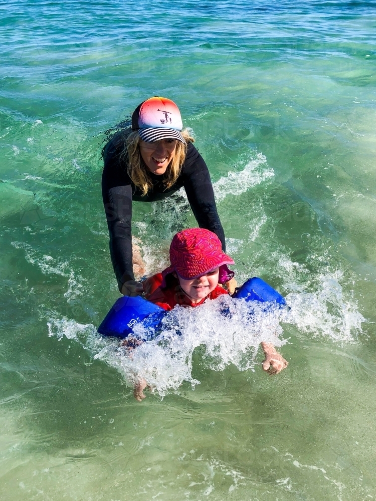 Mother and daughter playing in the ocean together - Australian Stock Image