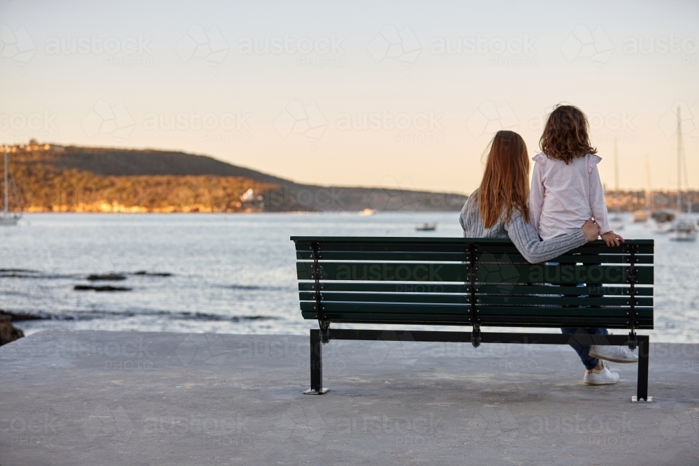 Mother and daughter sharing time laughing at beach promenade - Australian Stock Image