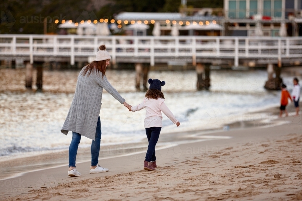 Mother and daughter sharing time laughing at beach promenade - Australian Stock Image