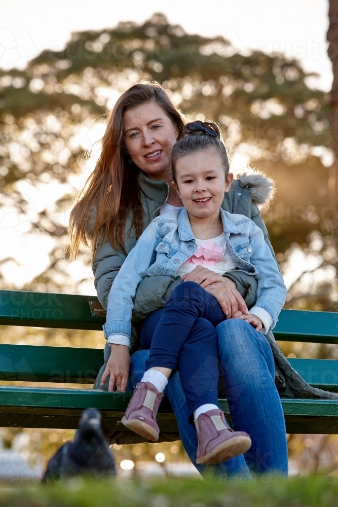 Mother and daughter sharing time laughing at park - Australian Stock Image