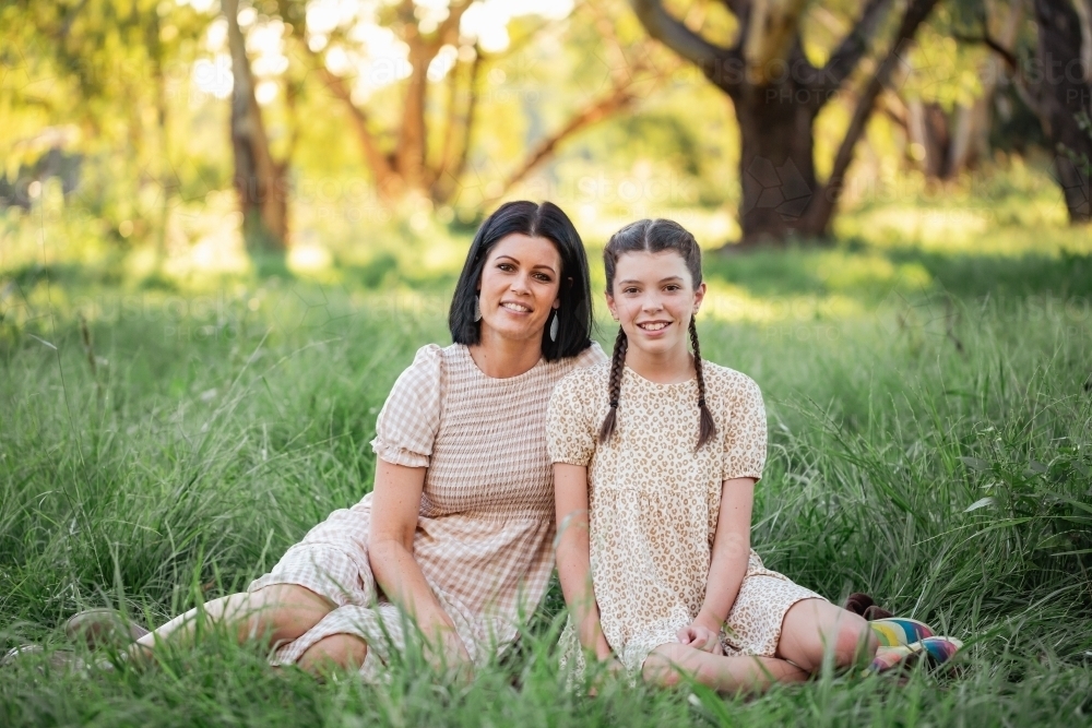 Mother and daughter sitting together in natural Australian bush setting - Australian Stock Image