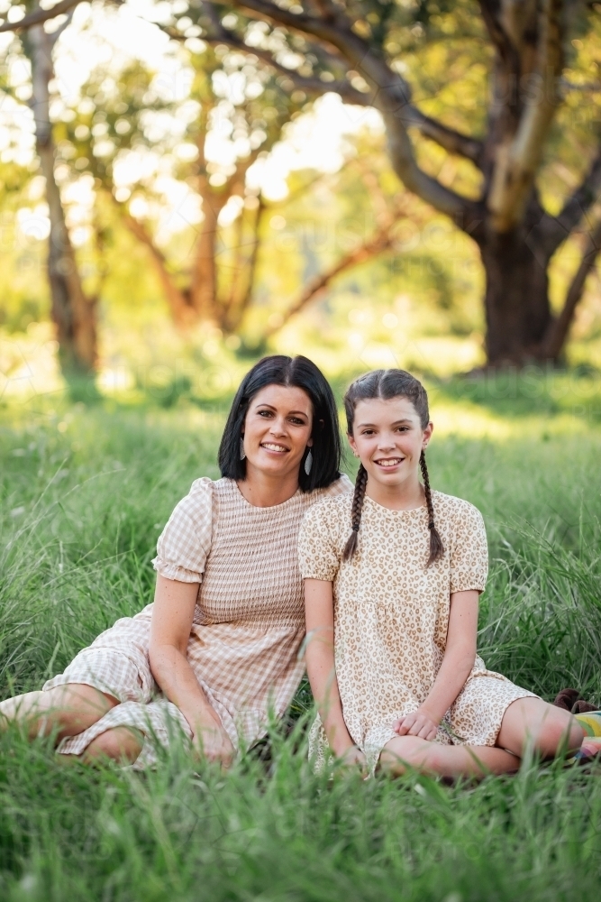 Mother and daughter sitting together in natural Australian bush setting - Australian Stock Image