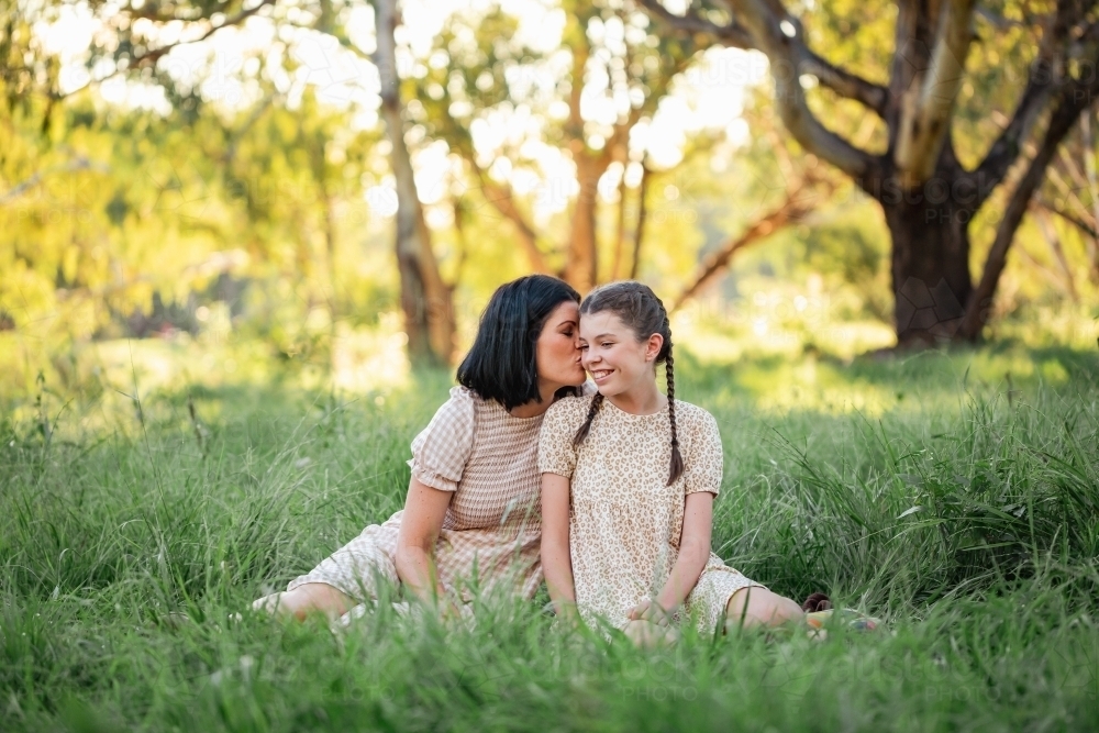 Mother and daughter sitting together in natural Australian bush setting - Australian Stock Image