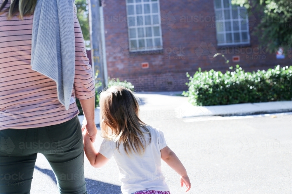 Mother and daughter walking away from camera - Australian Stock Image