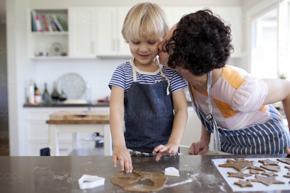 Mother and son in kitchen at home baking gingerbread cookies - Australian Stock Image