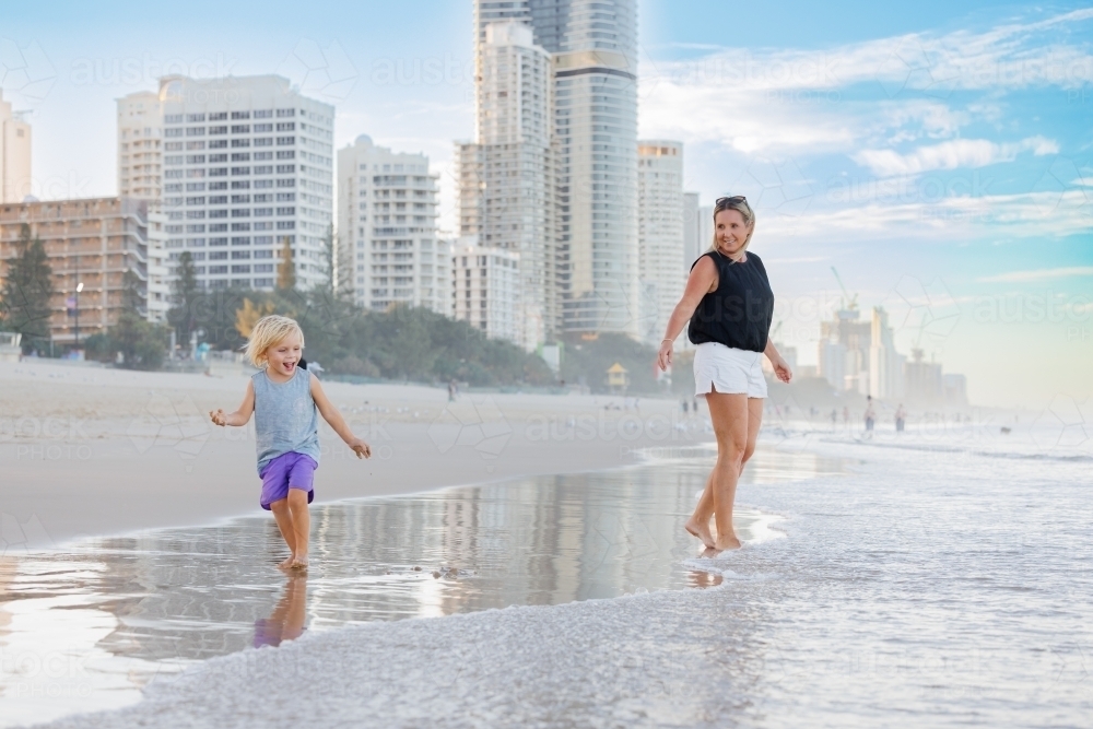 Mother and son playing in shallow water on Main Beach, Surfers Paradise on the Gold Coast - Australian Stock Image