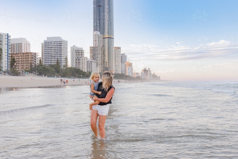 Mother and son playing in shallow water on Main Beach, Surfers Paradise on the Gold Coast - Australian Stock Image