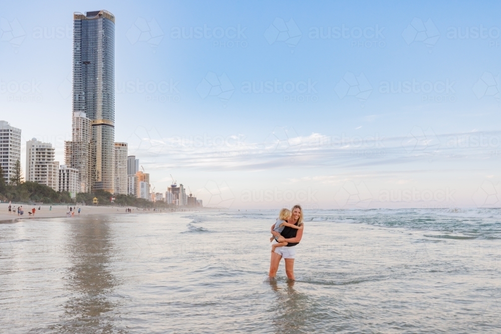 Mother and son playing in shallow water on Main Beach, Surfers Paradise on the Gold Coast - Australian Stock Image