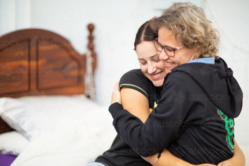 Mother and teen daughter hugging - Australian Stock Image