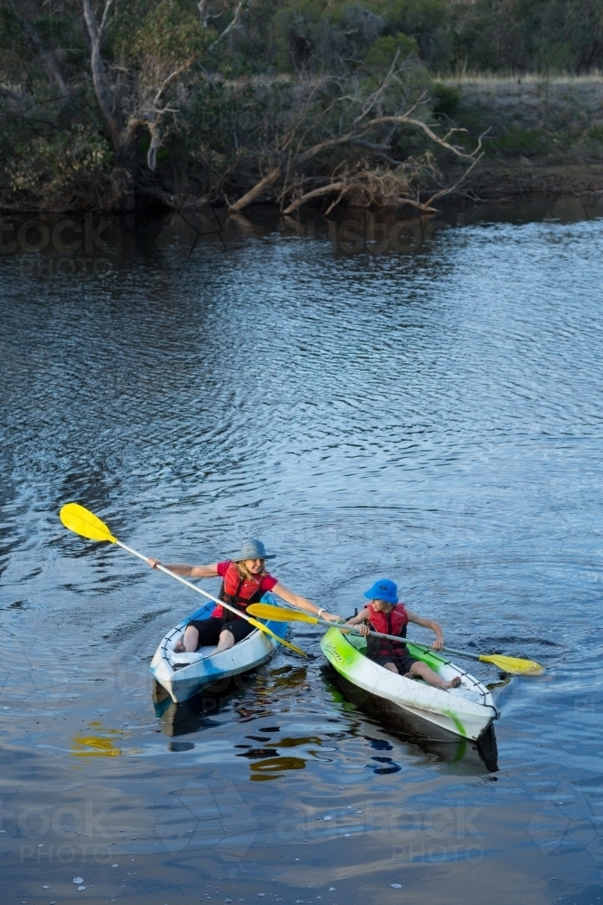Mother assisting child in kayak - Australian Stock Image