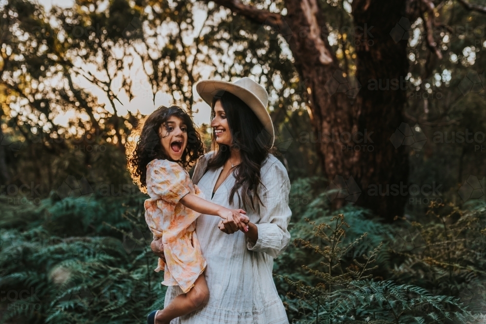 Mother carrying the daughter in the park - Australian Stock Image