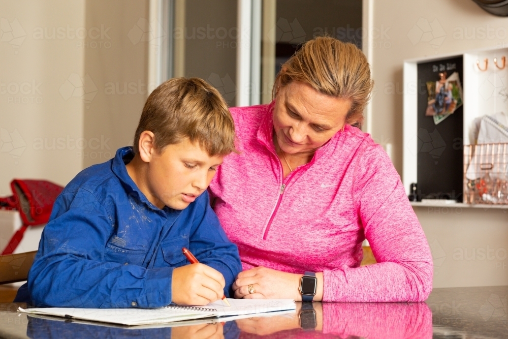 Mother helping child with homework - Australian Stock Image