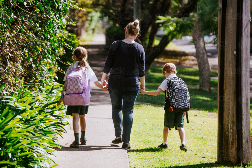 Mother holding hands with her children on walking path - Australian Stock Image