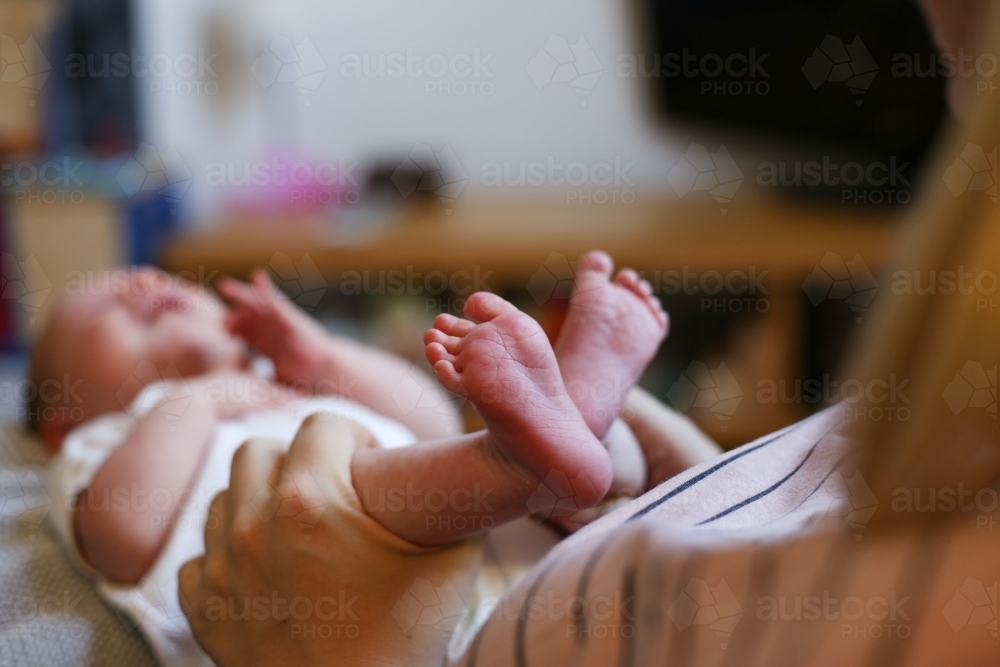 Mother holding new-born baby by the legs - Australian Stock Image