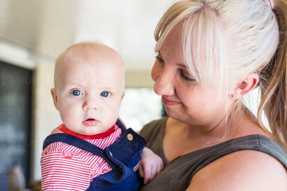 Mother holding son looking at him smiling - Australian Stock Image