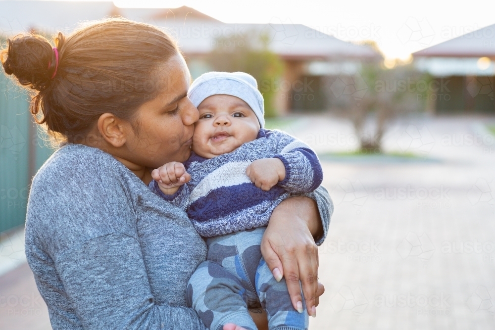 Mother kissing and cuddling her baby boy - Australian Stock Image